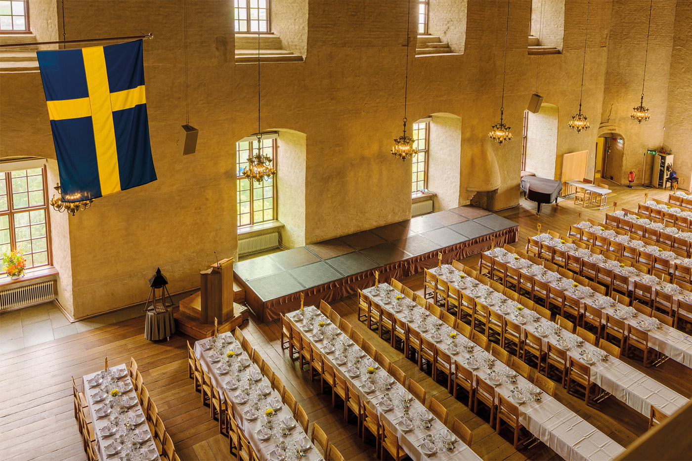 Långbord utplacerade framför scenen i Rikssalen på Uppsala Slott